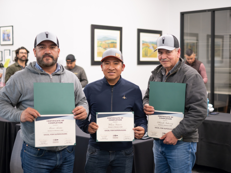 Three men holding certificates after training completion.