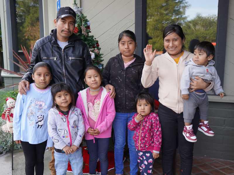 Family posing together outside during Christmas season.