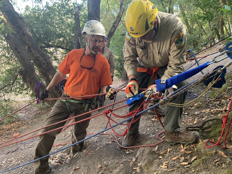 Rescue team training with ropes and safety gear.
