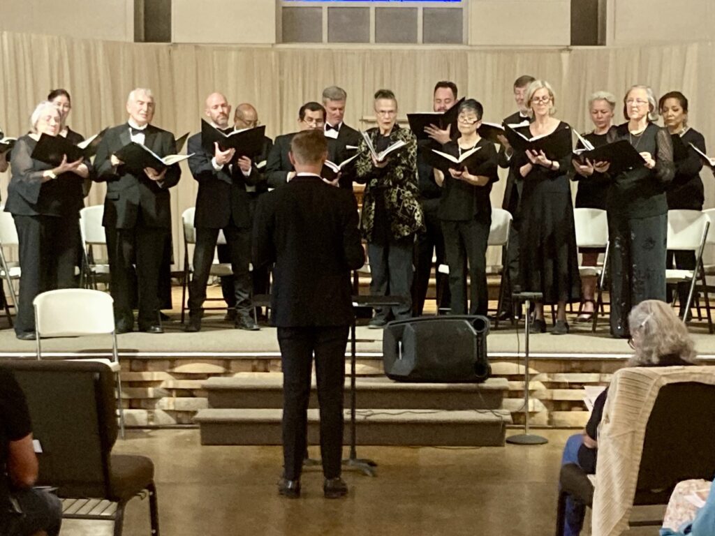 Choir performing on stage with conductor.